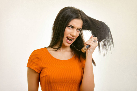 纠结凌乱的发型问题。女人刷牙她受损的头发