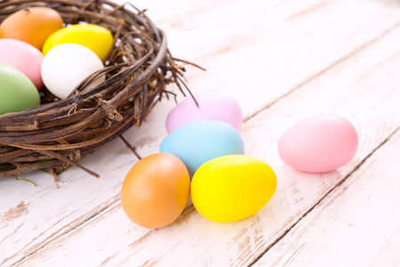 五颜六色的复活节彩蛋在巢在质朴的木板背景。放假。复古粉彩色调。关闭组合
