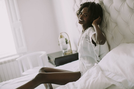 漂亮的年轻非洲裔美国妇女躺在床上的白色