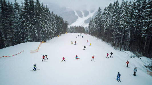 滑雪者和滑雪沿着斜坡在滑雪胜地 Bukovel, 乌克兰