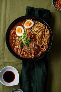 碗与日本拉面与猪肉肚和蘑菇与蛋在绿色亚麻桌布