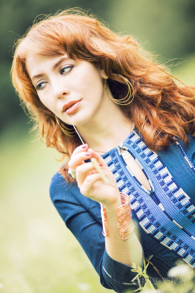 漂亮的红发女孩在一个字段中