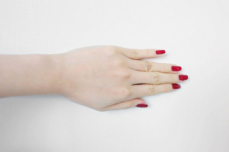美丽的女人红指甲。女性手与红色指甲指甲隔离在白色的墙壁背景伟大的任何使用