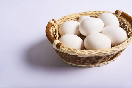 白鸡新鲜鸡蛋在木篮中孤立的白色背景