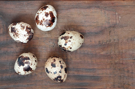 鹌鹑蛋在深褐色的木质表面上, 顶部视图, 空的地方为文本, 食谱