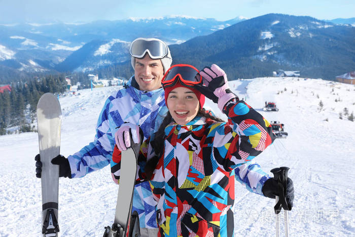 雪背道而驰滑雪胜地的快乐情侣。寒假