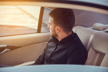 英俊的男士穿着黑色衬衣的英俊时髦男士坐在车里照片