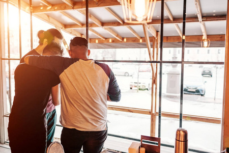 一群朋友拥抱和检查在休息室酒吧智能手机图片。年轻男人玩得开心