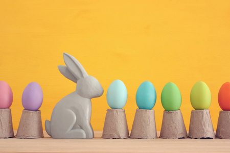 可爱的兔子旁边的复活节五颜六色的彩蛋彩色背景