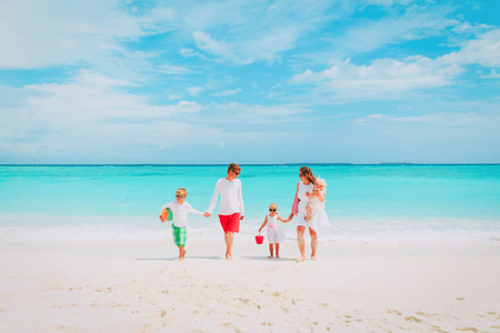 幸福的家庭，和三个孩子走在海滩上