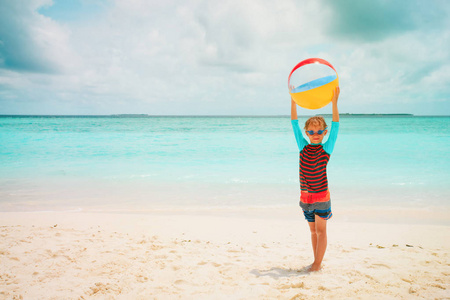 快乐的小男孩在沙滩上玩球