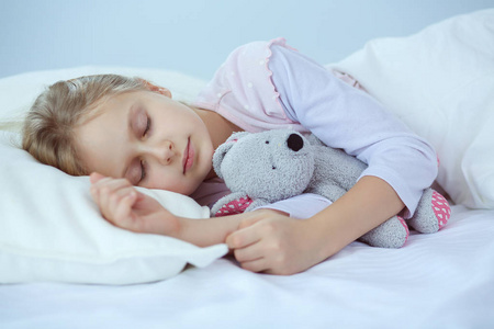 儿童小女孩睡在床上有一只玩具泰迪熊