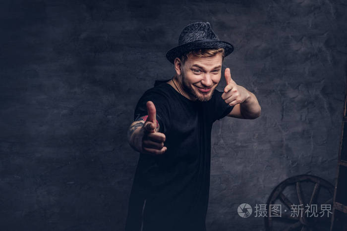 肖像的正面胡子男性与纹身武器 身着黑色t恤和帽子显示良好的手照片 正版商用图片04lkvk 摄图新视界 肖像的正面胡子男性与纹身武器 身着黑色t恤和帽子显示良好的手照片 正版商用图片04lkvk 摄图新视界