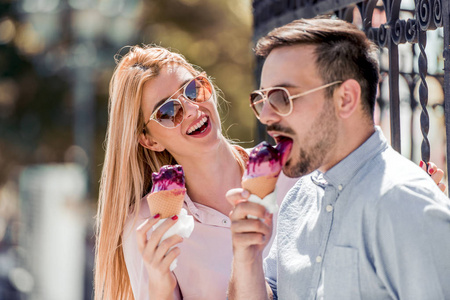 年轻夫妇在城市吃冰淇淋
