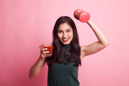 健康的亚洲女性哑铃和番茄汁