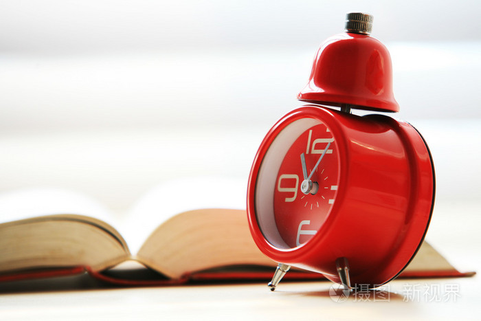 与红色闹钟打开的书
