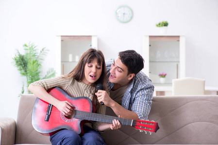 在家唱歌和演奏音乐的年轻家庭图片