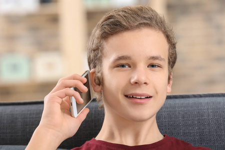在电话室内交谈的少年男孩与助听器谈话