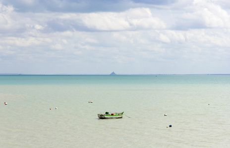 背景下的 mont 圣平静的蓝色海面上一艘船