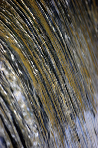 水流瀑布流飞溅背景, 大细节垂直特写, 明亮的蓝色, 金色, 黄色, 海绿色粉彩色彩运动模糊滴纹理图案, 柔和的质感散景