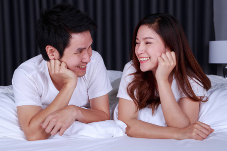 幸福的年轻夫妇在床上的卧室