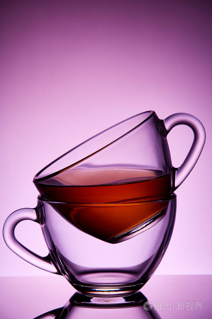 两个玻璃茶杯的概念组成在彩色紫色背景特写垂直