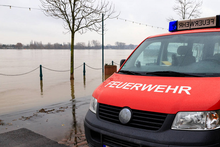 消防部门汽车在河被淹没的岸上
