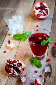 石榴鸡尾酒与冰薄荷和水果在木桌上。清凉夏日饮品