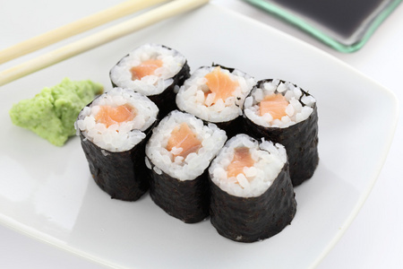 三文鱼 maki 寿司用筷子和酱油在白色 backgro