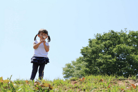 日本女孩在蓝天下吹蒲公英种子3年