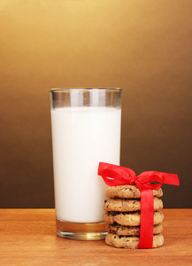 杯牛奶和棕色背景上的木桌上的饼干