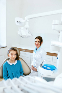 牙科保健。牙医和快乐女孩在牙科办公室