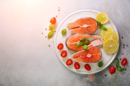 鲑鱼牛排配柠檬, 香草, 香料樱桃西红柿, 在灰色的具体背景。健康饮食观念。顶部视图。复制空间