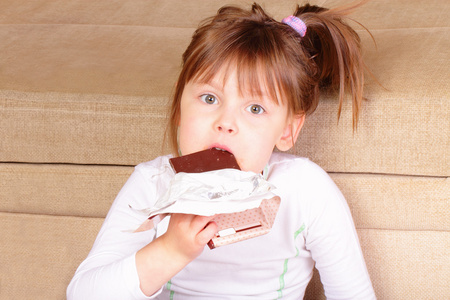 漂亮的小女孩吃巧克力