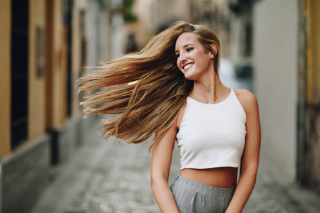 城市背景下运动头发的快乐年轻女性