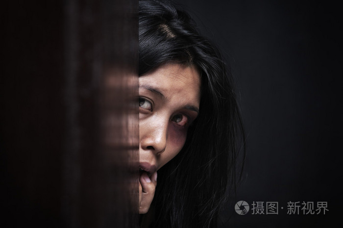 受伤的女人隐藏在黑暗中