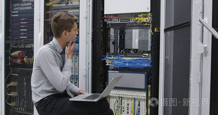 在服务器机房机架中执行维护任务的技术人员