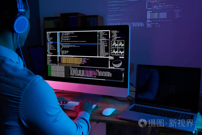 在电脑屏幕上检查他的代码的程序员