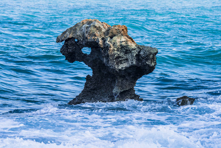 在塞浦路斯岛沿岸地中海海域的一只公羊头的形状的石头照片