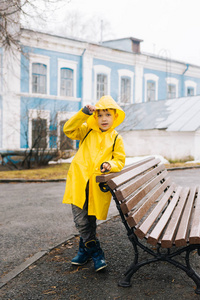 穿着黄色雨衣的快乐男孩在户外