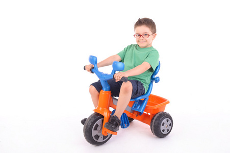 小男孩骑着他的三轮车