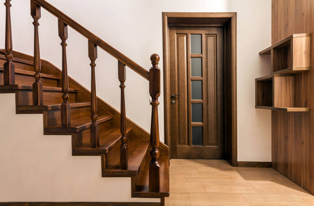 现代棕色橡木楼梯和门在新装修的房子