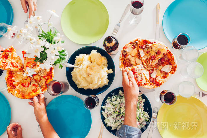 一家人吃东西喝.比萨饼, 沙拉, 土豆分享