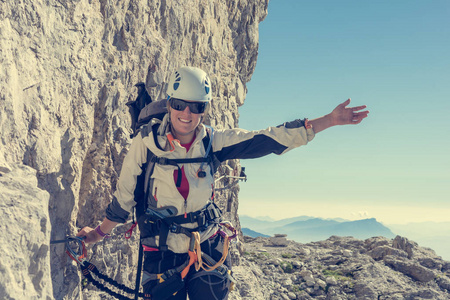 快乐的女登山运动员通过 ferrata 攀登