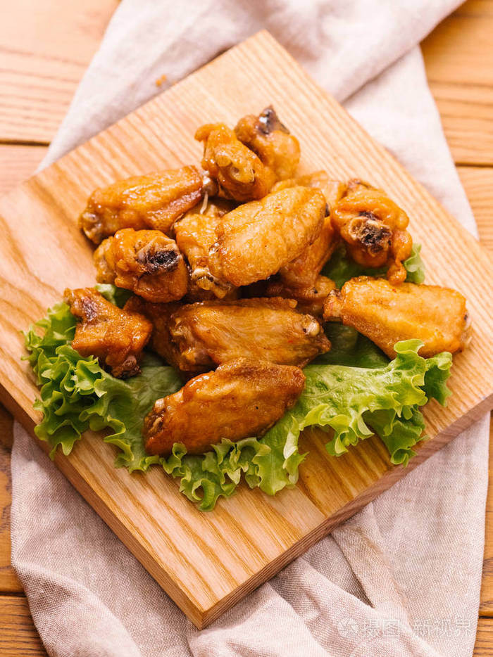 木制切板上配生菜的炸鸡翅