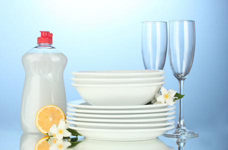 空清洁板及洗碗液体和柠檬在蓝色背景上戴眼镜