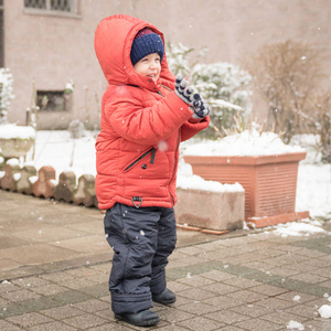 小男孩在下雪时乐呵呵地微笑。