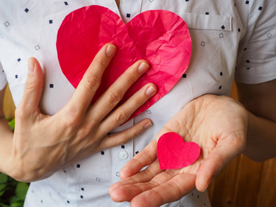 大而小的红色心脏在他的手照片