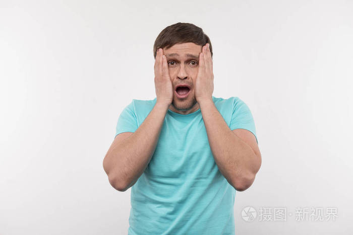 害怕的年轻人抚摸着他的脸颊