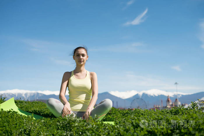 美丽的和平的妇女冥想户外在一个温暖的春天天, 从事瑜伽